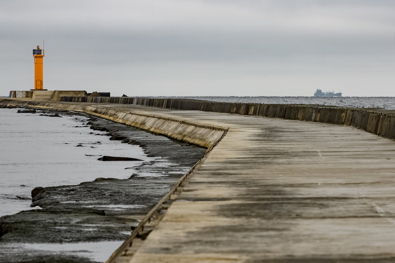 Seawall pier leading out to a lighthouse on the shores of Lake Michigan.